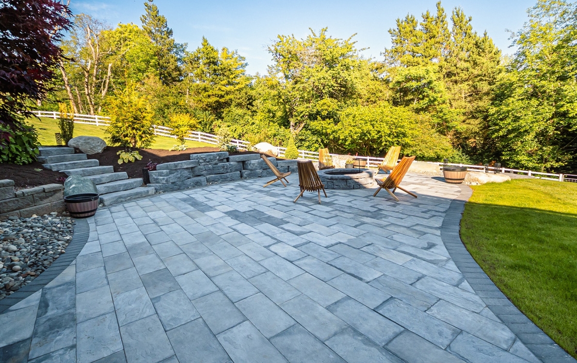Scuplted hardscape paver patio seating area with built in firepit